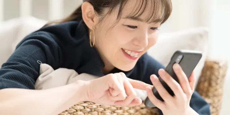 スマートフォンで動画を見る女性